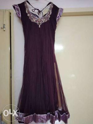 Purple net suit with churidar and dupatta.