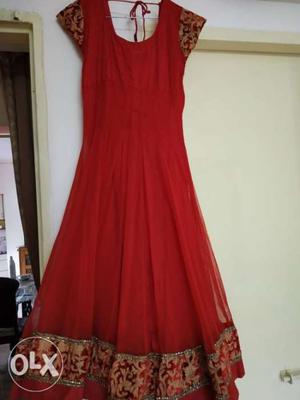 Red anarkali dress with churidar and dupatta.
