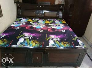 Black Wooden Bed Frame With Floral Bed Sheet