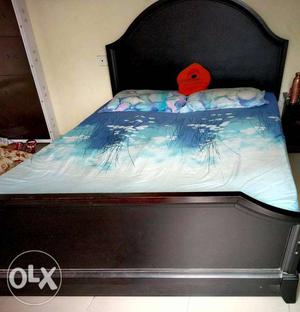 Black Wooden Bed Frame With Blue Bed Sheet