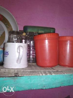 White Mug And Two Orange Plastic Containers