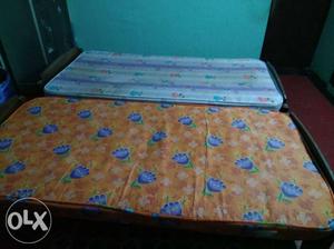 Brown Wooden Bed Frame With Blue And White Floral Mattress