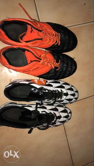 Two Pairs Of Black And orange football boots