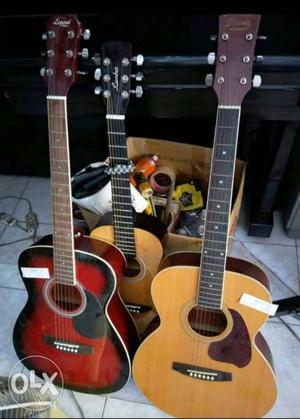 Two Brown And One Red Dreadnought Acoustic Guitars