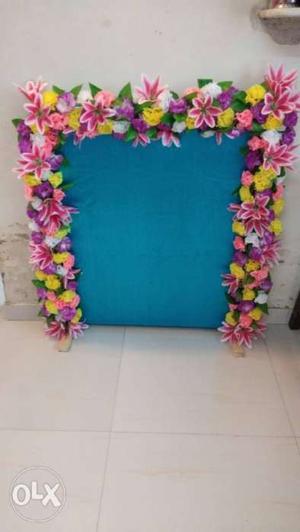 Pink And Yellow Artificial Flower Decors behind idol.