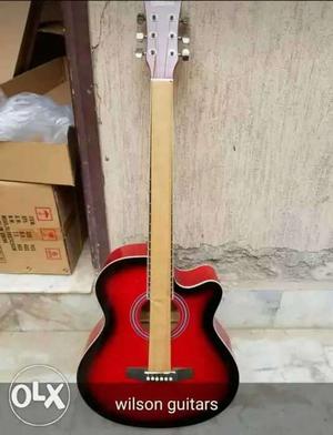 Red And Black Wilson Cutaway Acoustic Guitar With Text