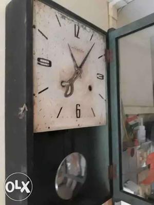 An antique clock with pendulam n key operated.