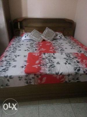 Brown Wooden Bed Frame With White, Black, And Red Floral