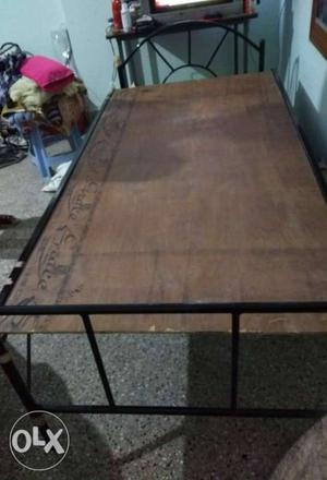 Rot iron cot and a wooden table for sale