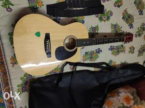 Brown Single-cutaway Acoustic Guitar And Green Guitar Pick