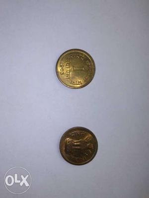Two Round Gold-colored 1 Indian Coins