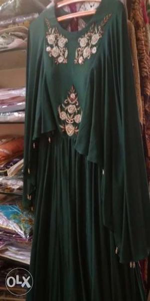 An exclusive cape style gown with zardozi work