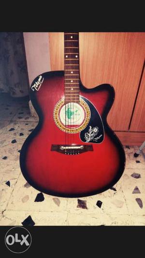 Red and black acoustic guitar had been used