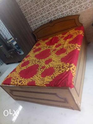 Brown Wooden Bed Frame With Red And White Floral Bedspread