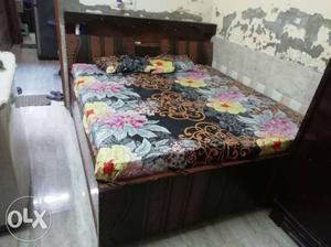 Brown Wooden Bed Frame With Floral Bed Sheet