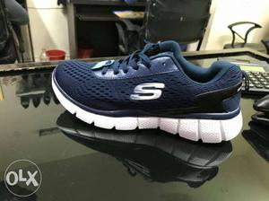 Pair Of Black-and-white Skechers Running Shoes