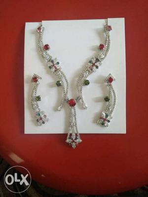 A rich designer necklace with a pair of earrings